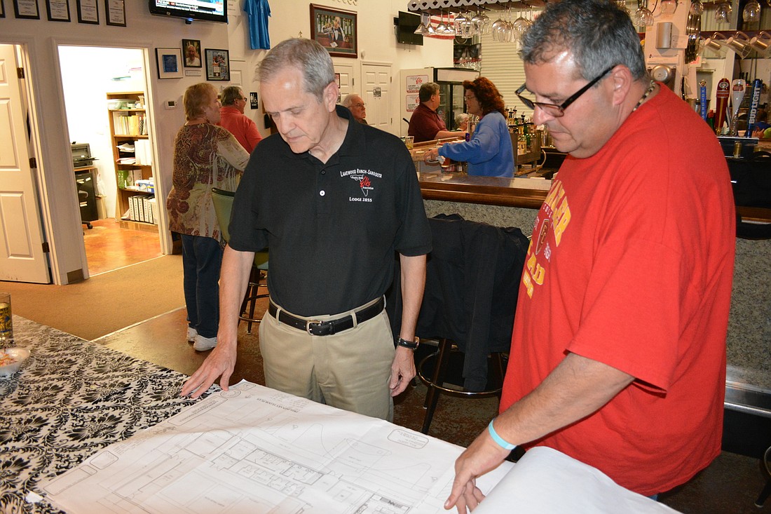 Elks Lodge members Randy Volkart and Darrin Simone look over design blueprints for their new lodge.