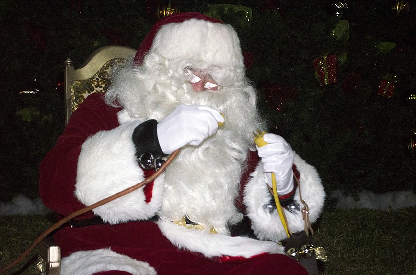 Santa Claus plugs in the the downtown Christmas tree last night at Five Points Park.