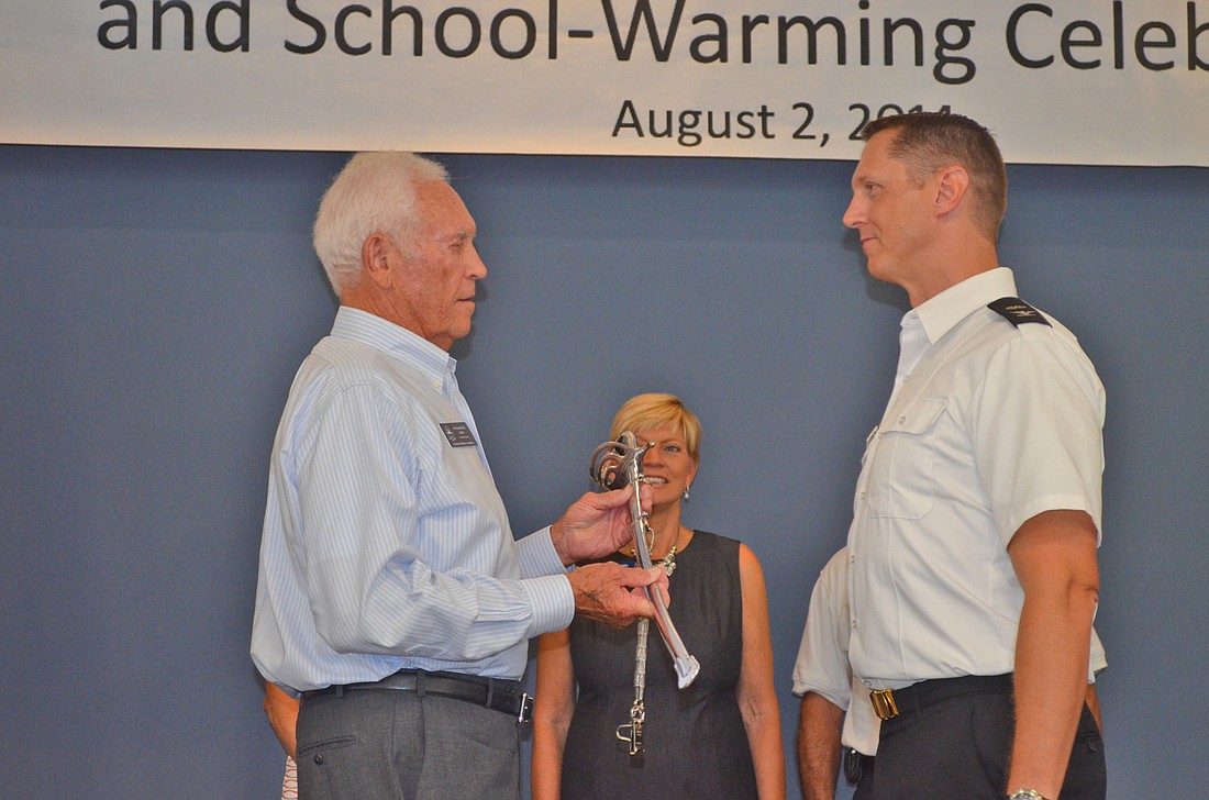SMA Board of Directors Treasurer Capt. Fred Derr presens former SMA Prep Head of Schools Phillip Eddy with a ceremonial saber Aug. 2, 2014.