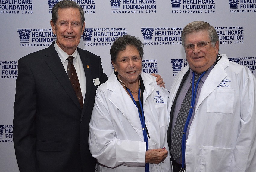 Chairman of the Sarasota Memorial Healthcare Foundation Board of Trustees Jim Syprett with Judy Zuckerberg and George Kole after receiving their Doctors of Philanthropy lab coats