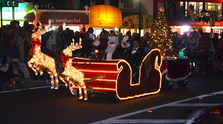 Santa Claus waves as the crowd cheers him on at 38th Annual Holiday Night on St. Armands.