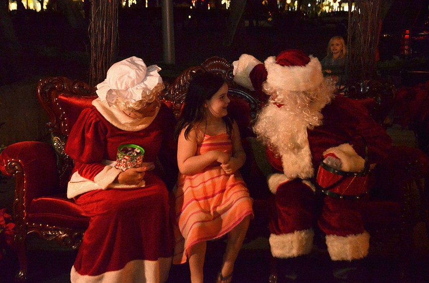 Emily Alley 6, laughs with Santa and Mrs. Claus as she tells them what’s on her Christmas list.