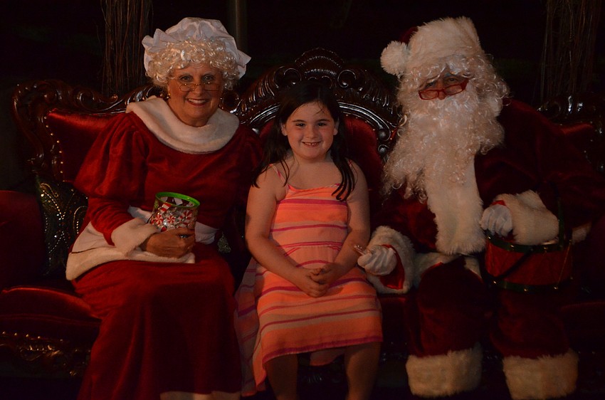 Emily Alley, 6, with Mrs. Claus and Santa Claus