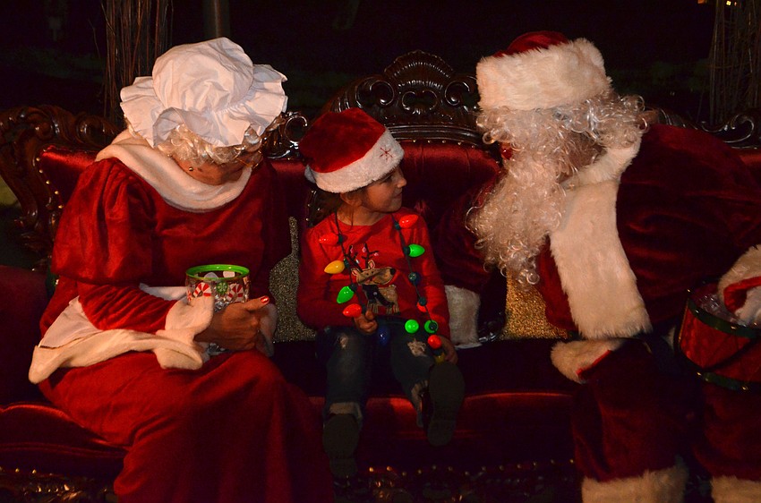 Adrianna Minore, 5, tells Santa Claus what’s on her Christmas list.
