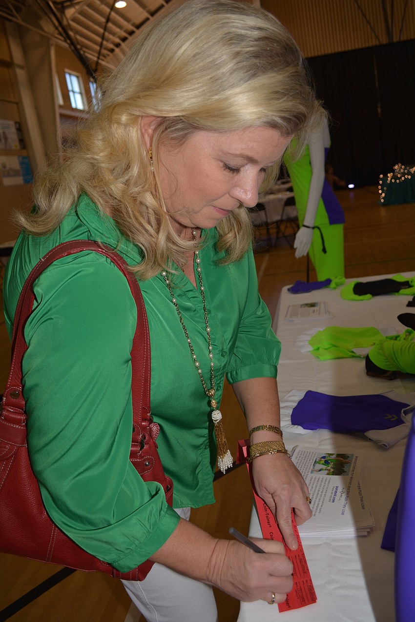 Lakewood Ranch' s Heather Macdonald checks out designs by Purabell House of Fashion, while filling out her raffle tickets.