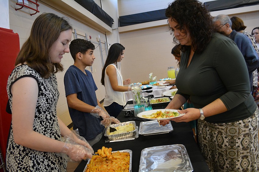 Lakewood Ranch High School' s Brittney Downing, 16, serves pasta to Waterlefe resident Valentina Kennedy.