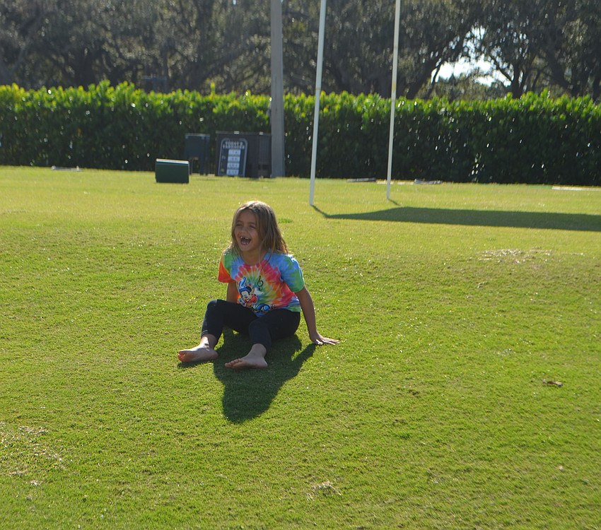 Alexandra Misantone, 6, laughs as she plays on the islandside driving range of the Longboat Key Club during the lawn party.