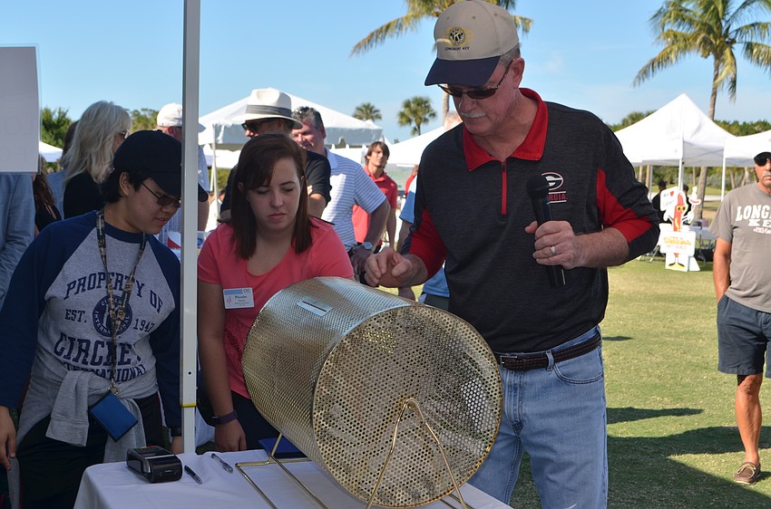 Kiwanis Club President Steve Branham pulls the winning raffle ticket for a dinner at The Lazy Lobster and Longboat Limousine ride.