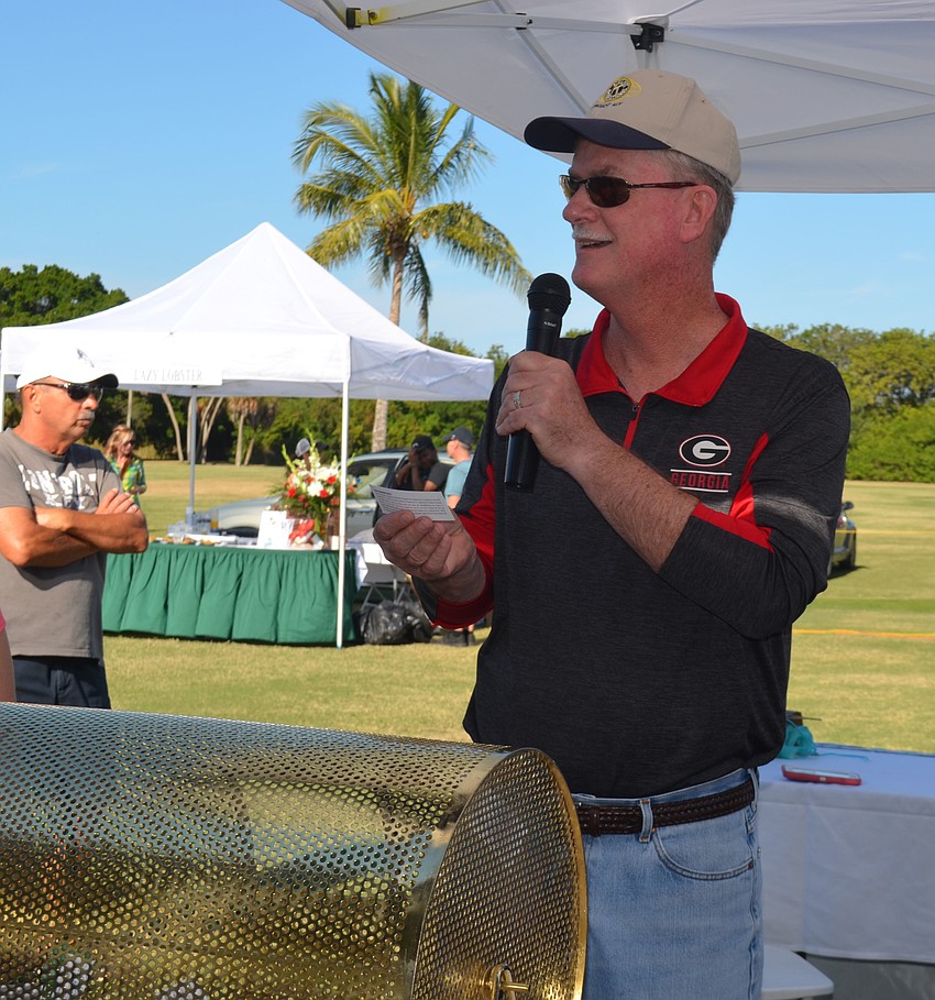 Kiwanis Club President Steve Branham announces the winner of a  dinner for 10 at The Lazy Lobster and Longboat Limousine ride.