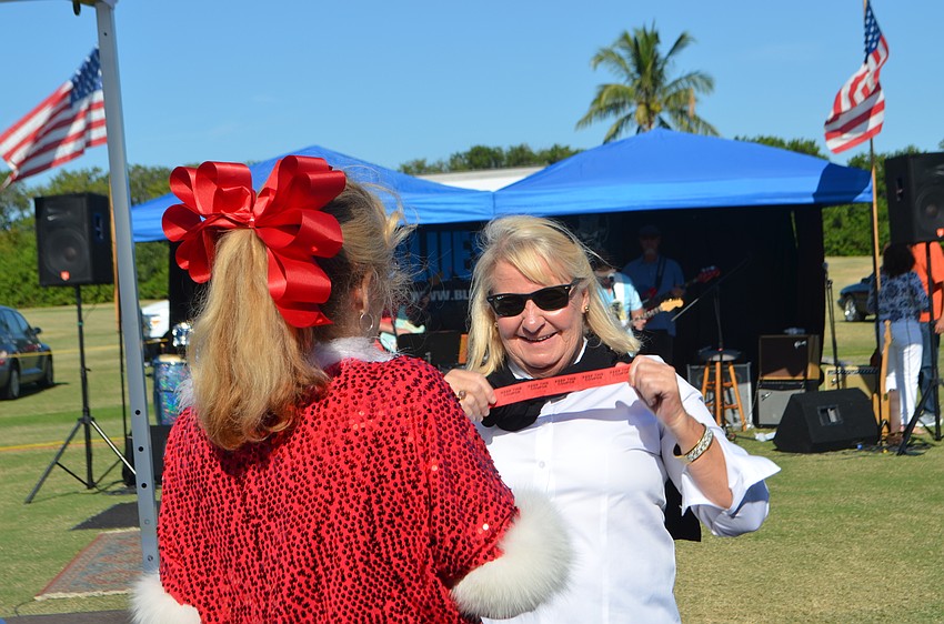 Ann Maloney shows her winning 50/50 raffle ticket to Lynn Larson.