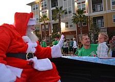 Santa (Bradenton' s Tom Jensvold) tries to get 2-year-old Evan Billingham of Lakewood Ranch to give him a high five, as Evan' s dad, Dr. Chris Dillingham, looks on.