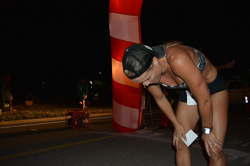 Kelly Jaco tries to catch her breath after winning the women' s portion of the Jingle Bell Run in 21:15.