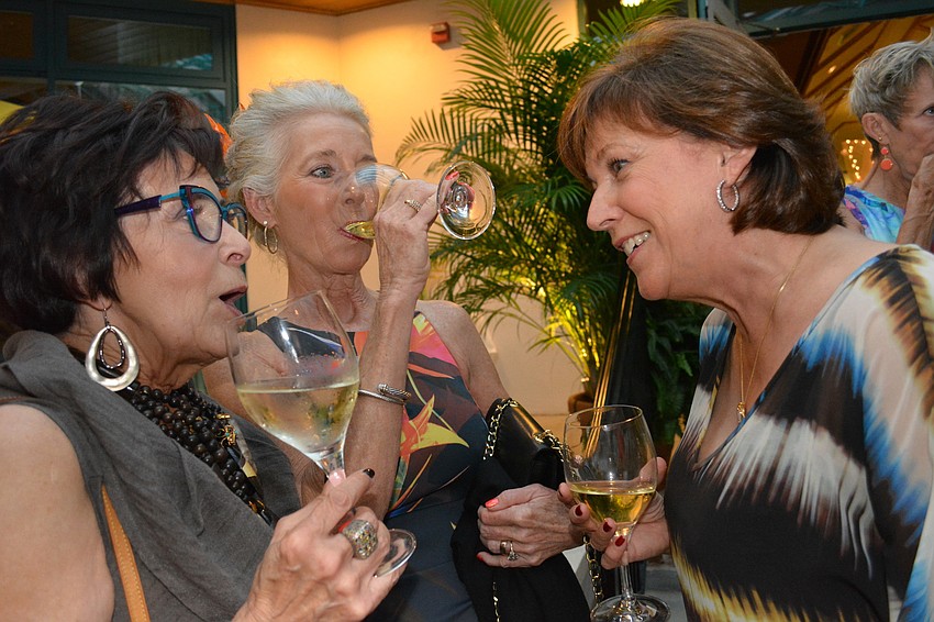 Catherine Strongman, Nancy Kopnisky and Anne Walsh are caught up in conversation during the social hour outside.