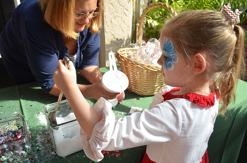 Ava Hays, 5, makes a holiday craft with glitter and fake snow.