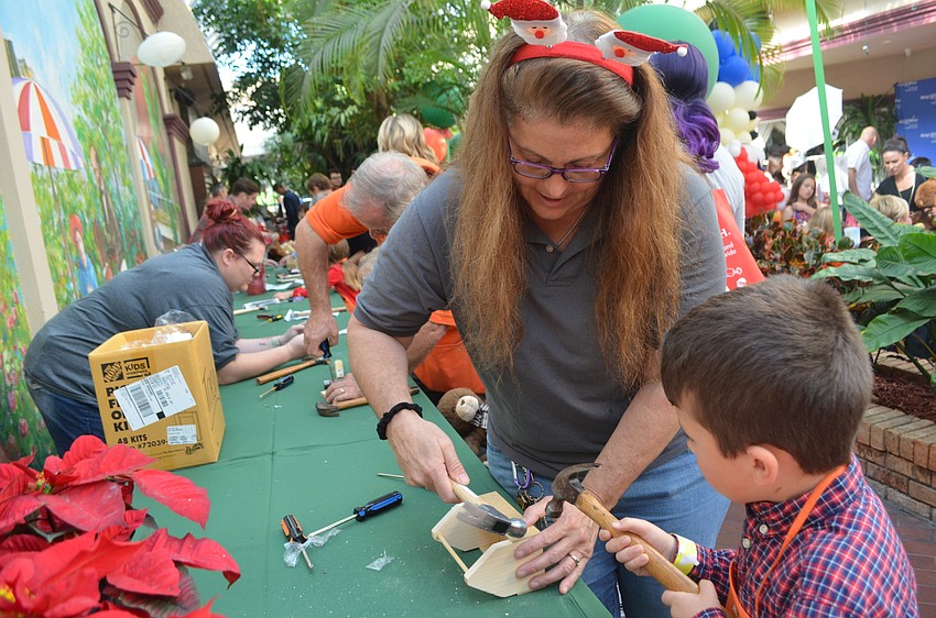 Jen Notario helps Ethan Freeman, 5, make a tool kit.