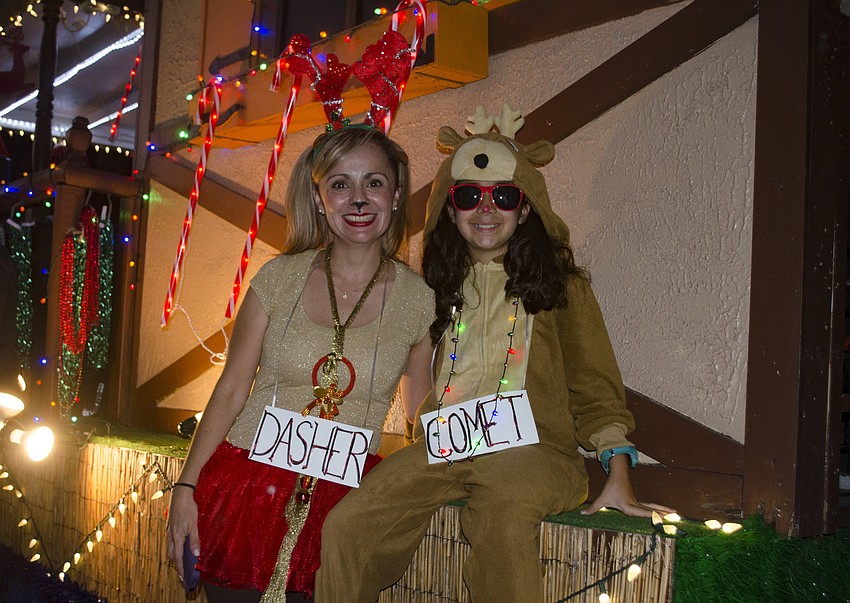 Cecilia Contreras and Andrea Mondragon sit on the Harbor Community Bank float before the parade began Saturday evening.