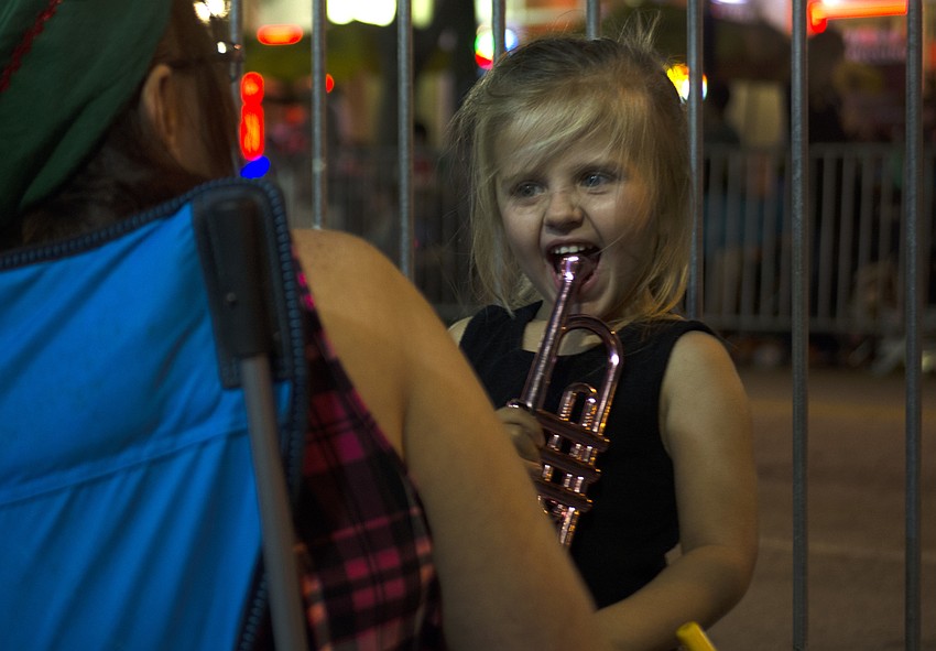 Photo 6: Kaylynn Sullivan laughs while playing with her toy horn before the Holiday Parade.