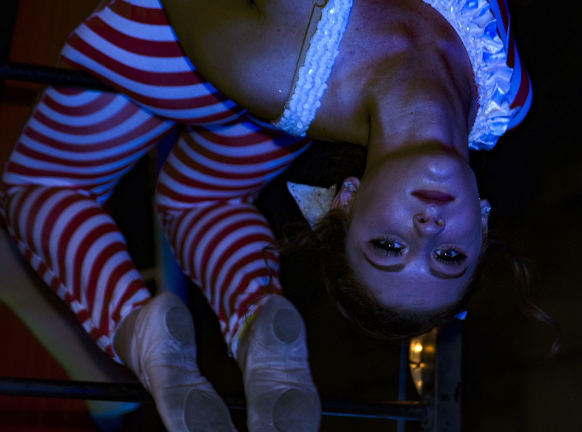 Lila Watkins practices her routine on the The Circus Arts Conservatory float before the parade began Saturday evening.