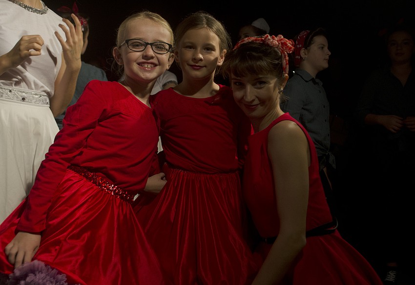 Gabriella Huff, Bella Brost and Chelsea March pose next to the Reflex Arts Dance float before the parade.