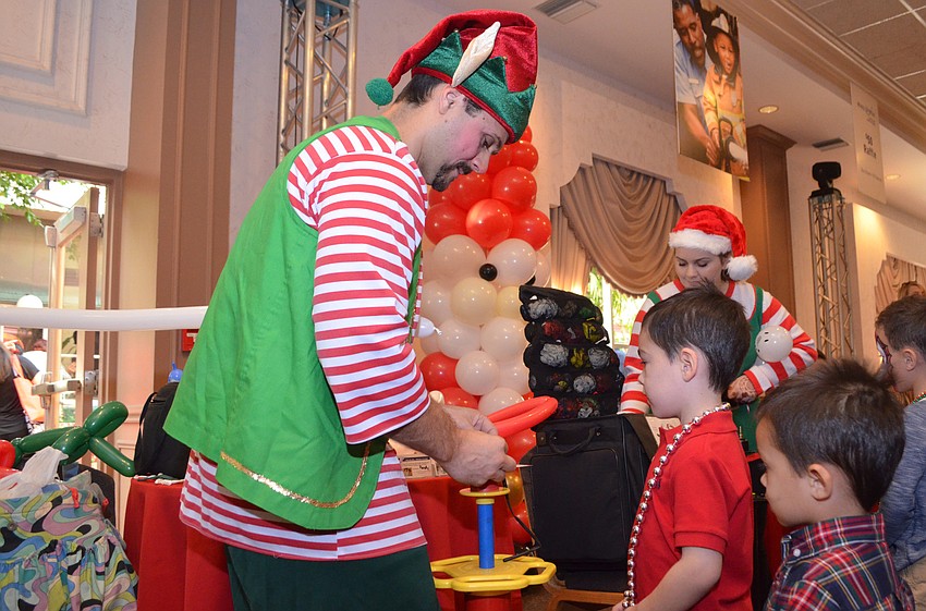 Dylan Sato, 4, and Brandon Sato, 3, watch in awe as a balloon figure is made for them.