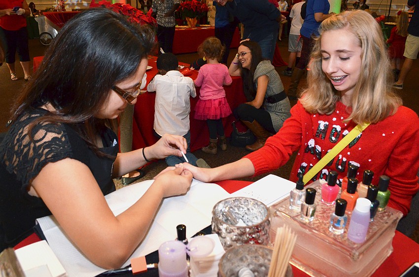 Lydia Vaccaro, 13, gets her nails painted by nail technician Stephanie Valdez of PAINT Nail Bar.