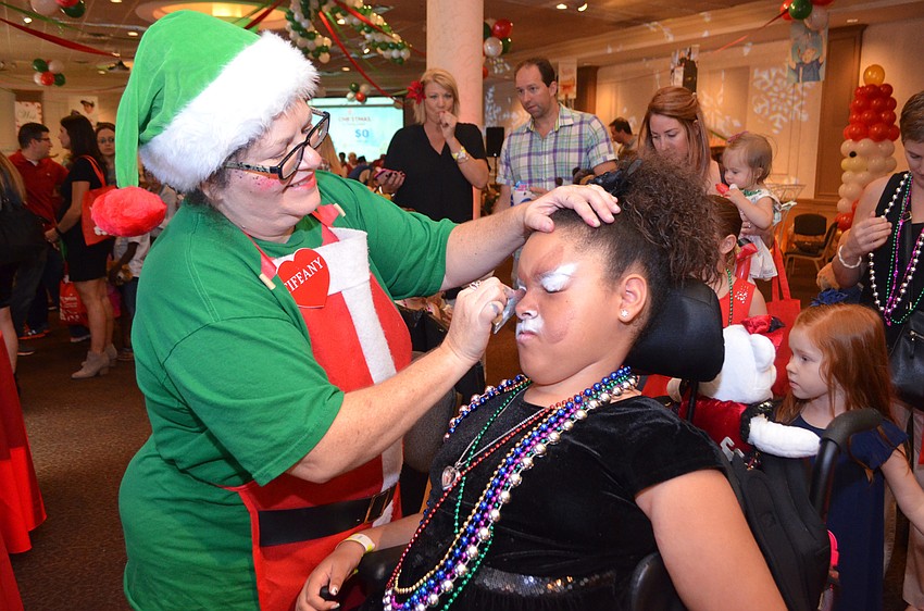 Tianna Rivera, 9, gets her face painted by Tiffany David.