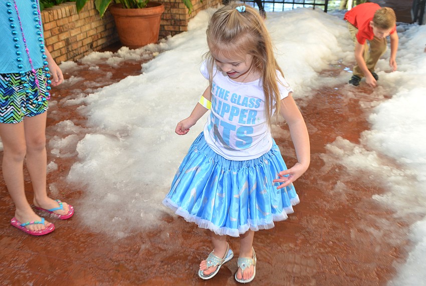 Abigail Moody, 3, enjoys the “snow” in the Michael’s On East courtyard.