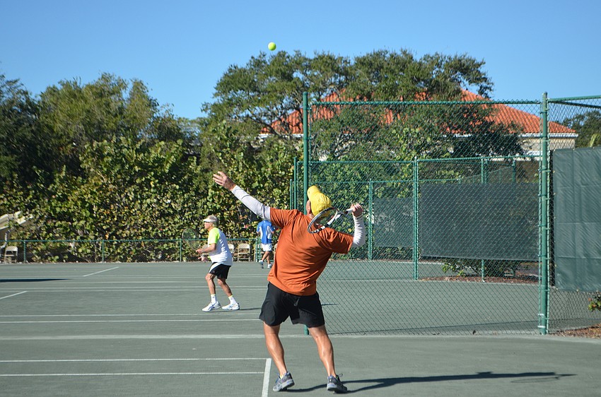 Alex Klitch serves the ball during the men'      s 55 doubles final match.