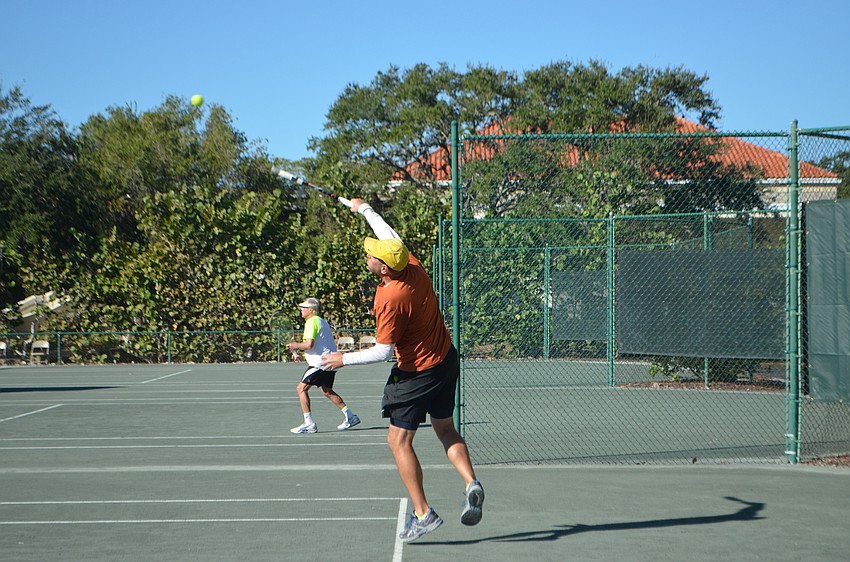Alex Klitch serves the ball during the men'      s 55 doubles final match.