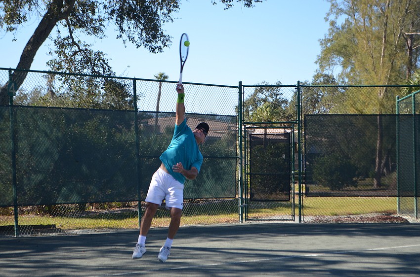 serves the ball during the men'      s 55 doubles final match.