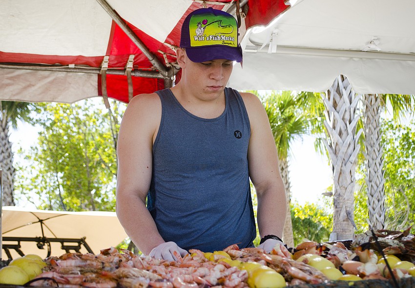 Russell Patt works at the Walt'    s Fish Market tent during the Siesta Beach Seafood and Music Festival.