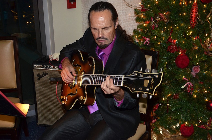 Andre Roy plays the seven-string guitar for attendees.