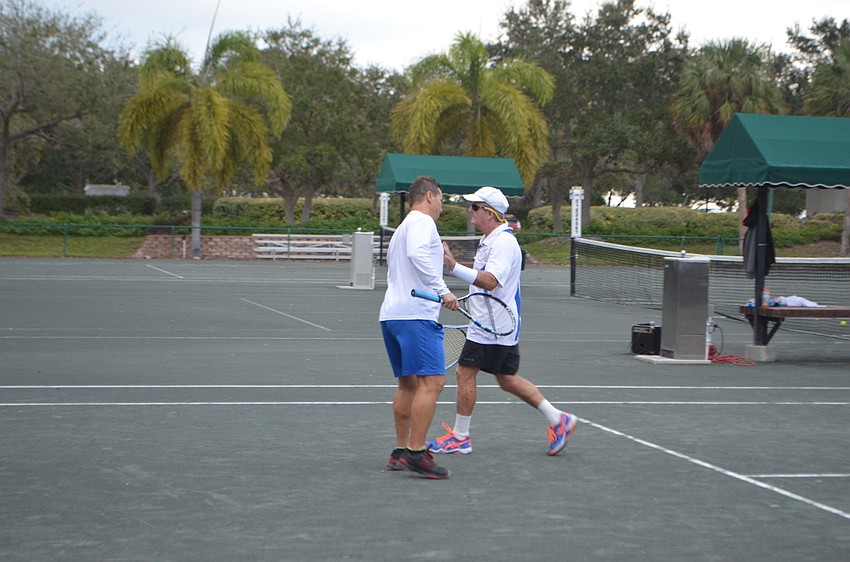 Sergio Pletosu and Warren Girle high-five during the exhibition match for the Observer Challenge Tennis Tournament.