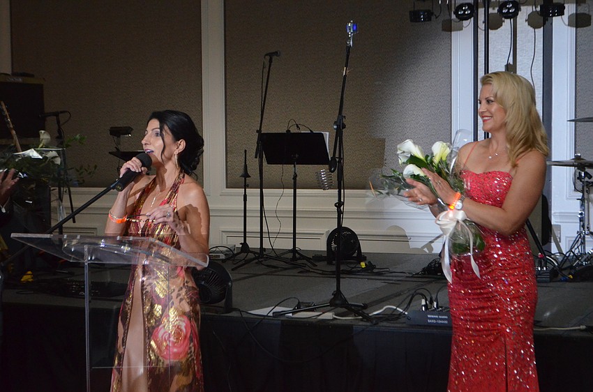 Johanna Gustafsson claps as her co-chairwoman, Barbara Najmy, thanks attendees for their support.