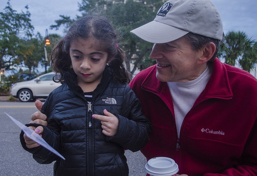 Mallory Rodriguez shows Marcus Heinrich how many items in the scavenger hunt she has found.