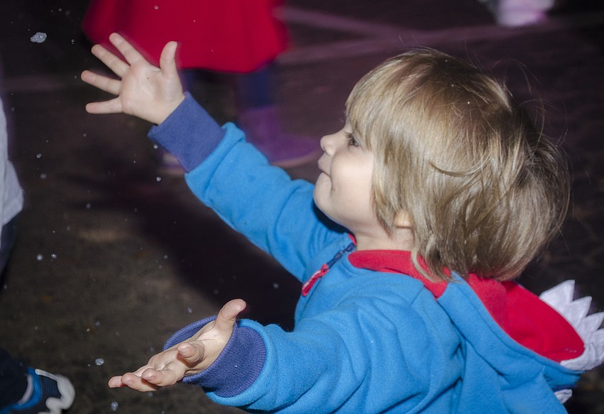 Julian Powell plays in the fake snow at the Southside Holiday Stroll.