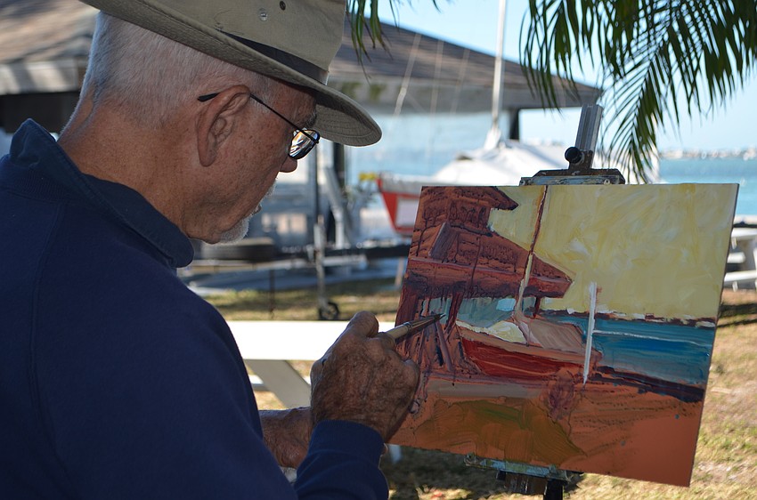 Joseph Melancon paints a boat resting near the Sarasota Bay.
