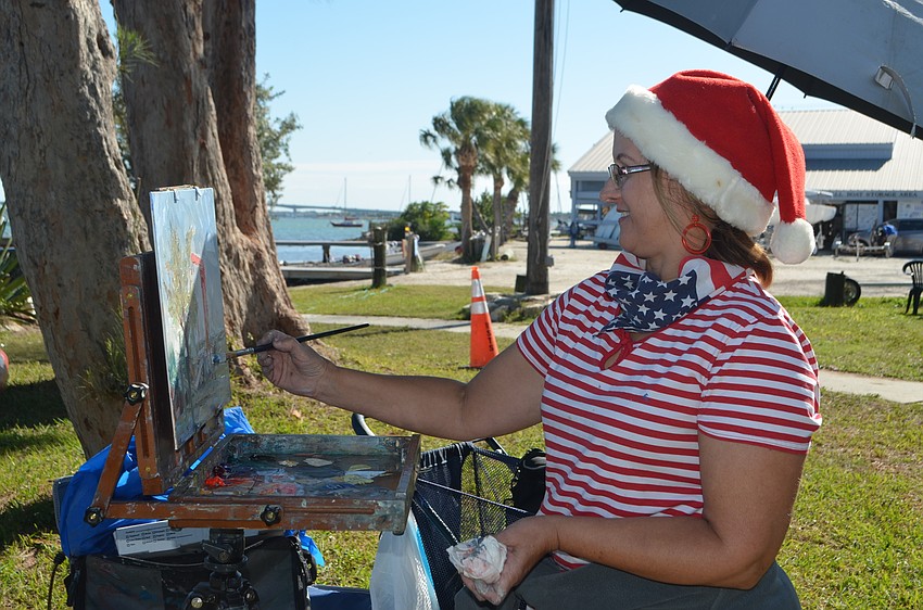 Lisa Swift smiles as she paints on Dec. 10 at the Sarasota Sailing Squadron.
