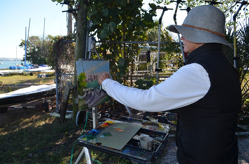 Jane Keeling, a teacher at The Renaissance School of Art, paints covered sailboats.