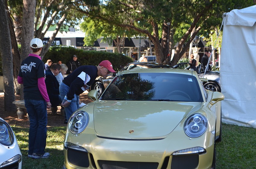Car enthusiasts check out the Porsches on display in St. Armands Circle Park.