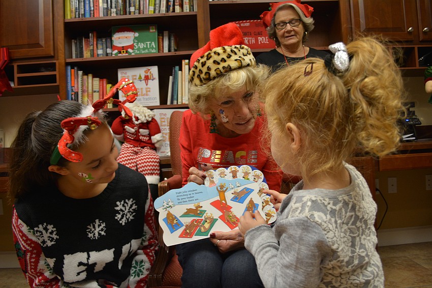 With the help of Isabella Pasquale, left, Cindy Bellacosa heps Olivia Jones, 3, read a story.