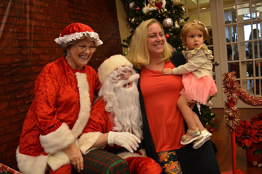 Mrs. and Mr. Claus (Jeanne and John Larranaga) pose with Beth and Mila Flamini.