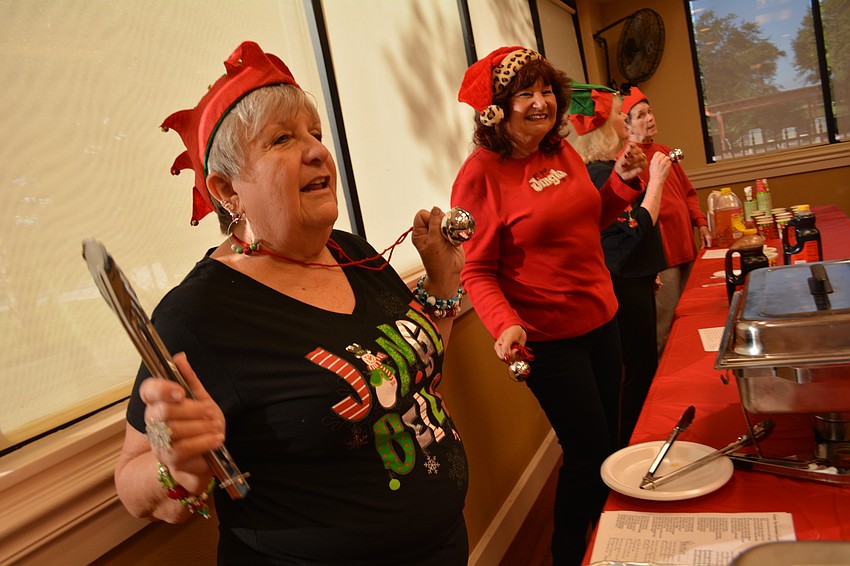 Linda Silagy dances to Christmas carols as she waits to serve up sausages.