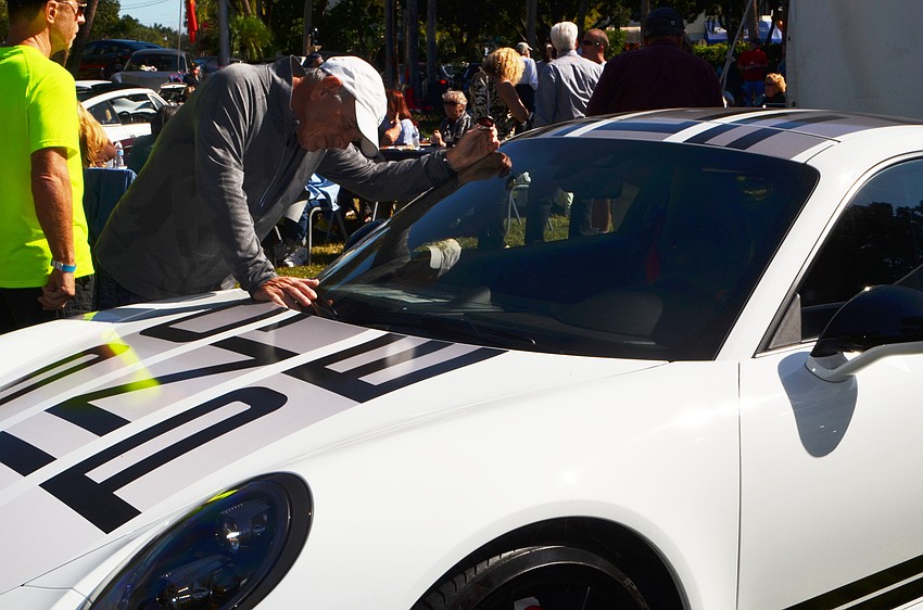 Tommy Bernstein checks out a Porsche on display during Porsches in the Park.