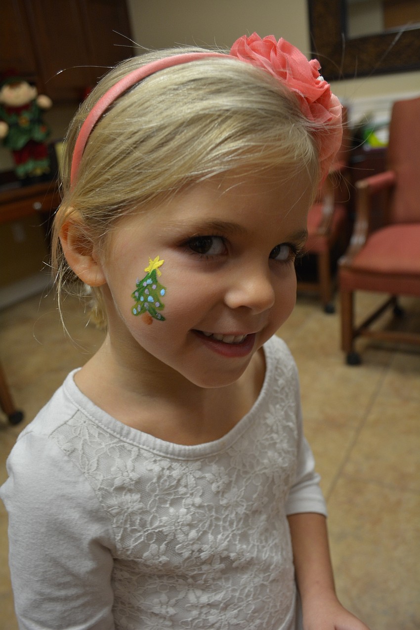 Sara Brantley, 5, shows off the Christmas tree painted on her face.