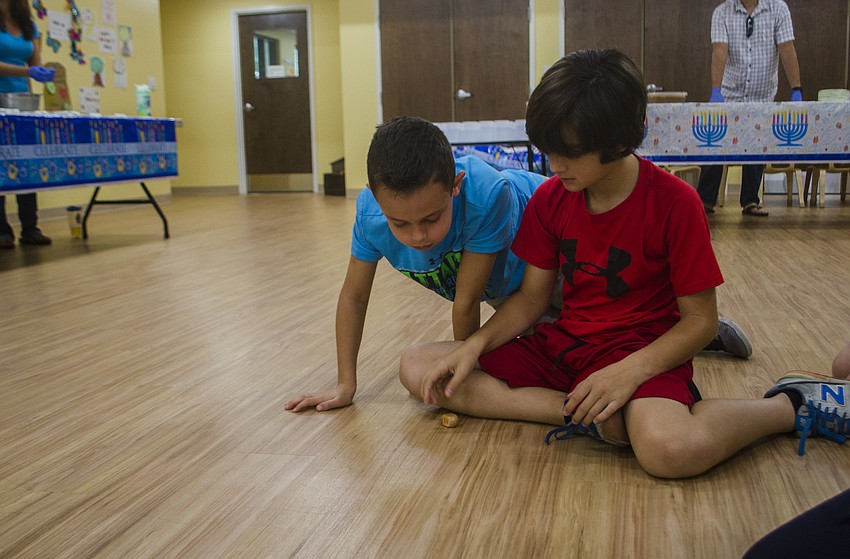 Eli Hannan and Rocco Rell play with a dreidel.