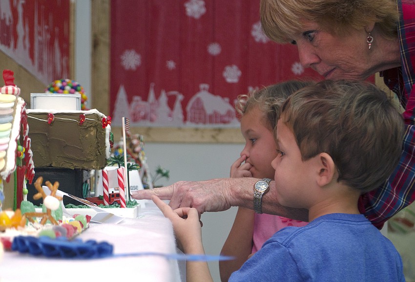 Joy, Levi and Jaime Webb admire Willis Smith Construction’s gingerbread house.