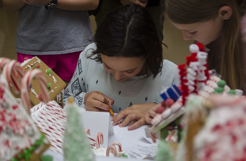 Gwen Hazel writes down her class’s submission to the Gingerbread Festival on her ballot for the people’s choice award.