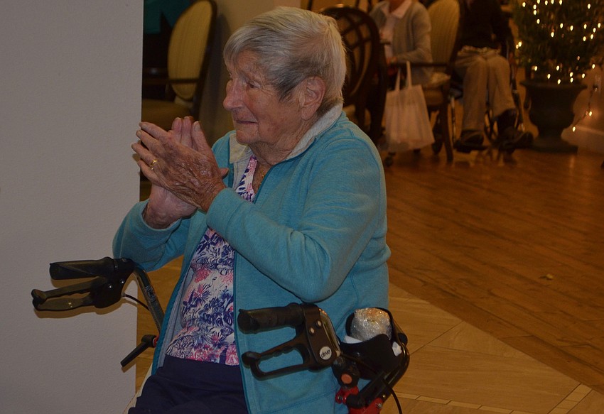 Cathy Illig, a resident at Inspired Living at Lakewood Ranch, claps to the Christmas carols.