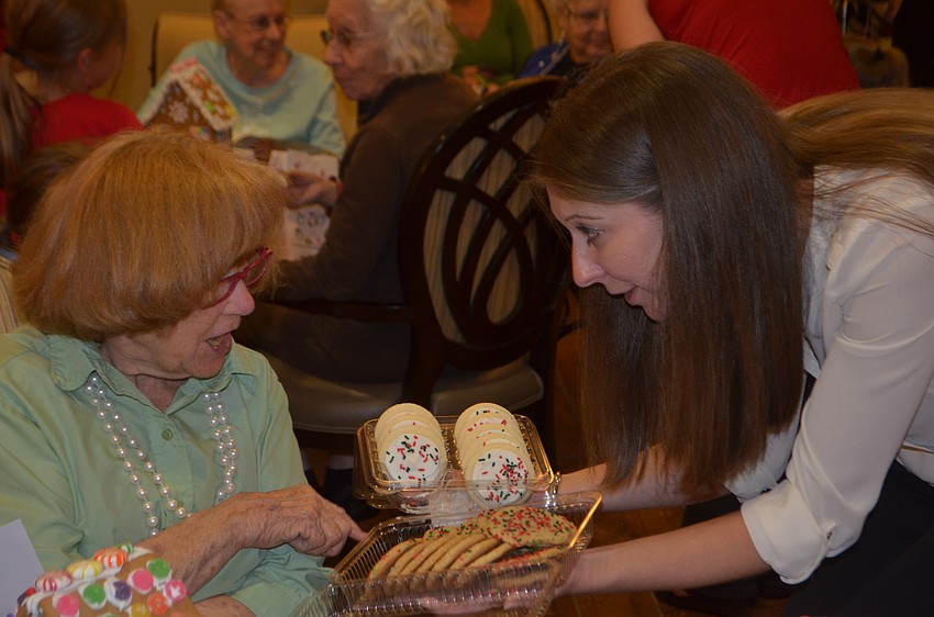 Betty Jones, an Inspired Living resident, chooses from an assortment of cookies presented by Palm Aire'   s Lisa Scott.